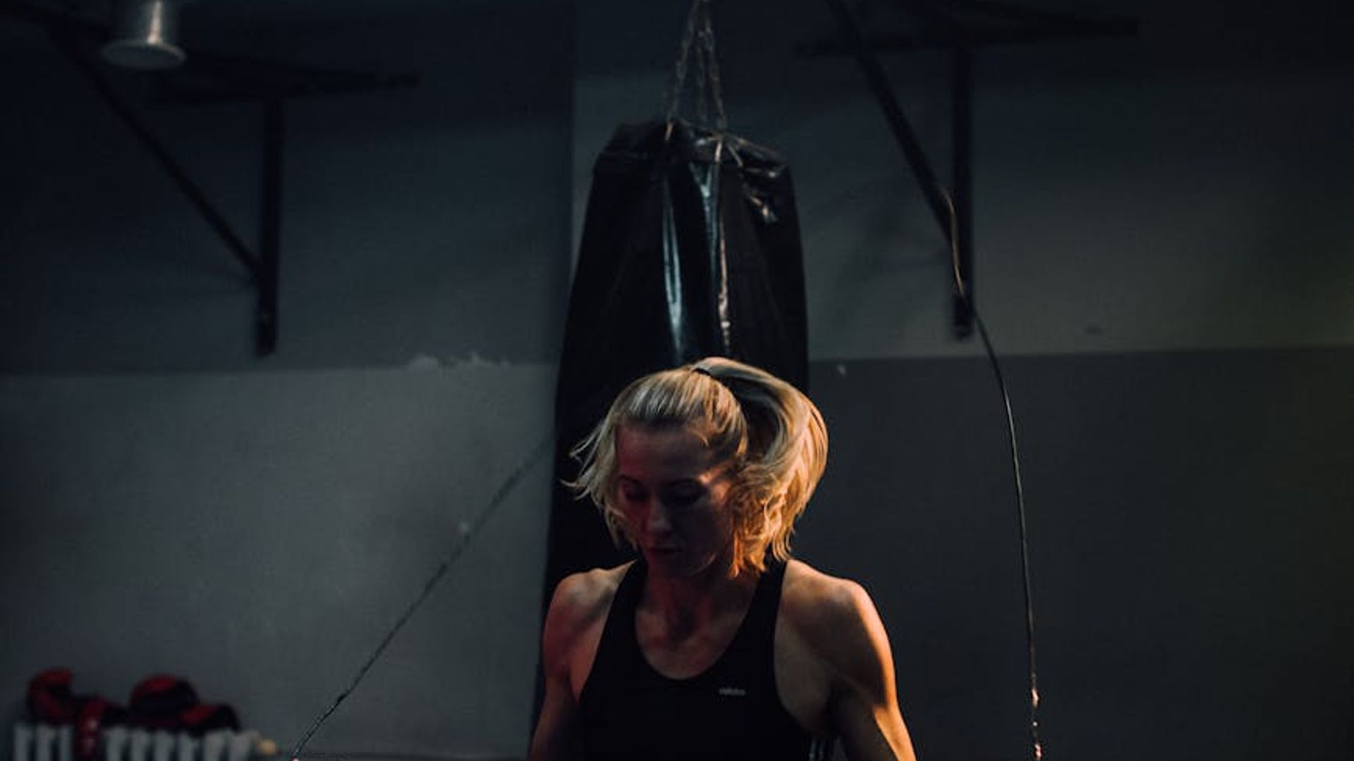 Strong athletic silhouette in a dark gym environment.
